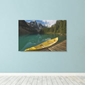 Canoe geparkeerd aan een dok langs het Moraine Lak Canvas Afdruk (Insitu (Houten vloer))