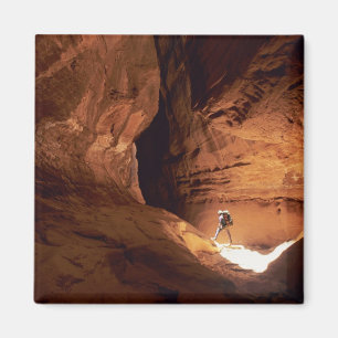 Canyoneer verlicht in de diepten van een smalle kl magneet