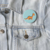 Cartoon oranje dinosaurus met pet ronde button 5,7 cm (In situ)