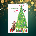 Chesapeake Bay Retriever, Vogel en Kerstboom Feestdagen Kaart<br><div class="desc">Op de voorkant van deze kerstkaart draagt een mooie Chesapeake Bay Retriever-hond een rood-wit Sinterklaasfeest pet terwijl hij naast een kerstboom zit. Licht verpakte cadeaupakketten zijn verspreid over, en een goudvink landt op de kerstboom. De rode en groene tekst zegt "Christmas JOY". Binnen is gestileerde tekst die VROLIJK KERSTMIS zegt,...</div>