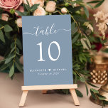 Chique Script Dusty Blue bruiloft receptie Kaart<br><div class="desc">Chique stoffige blauwe bruiloft receptie tafelnummer bord met "tafel" in een stijlvol modern wit script met swashes, het tafelnummer in elegante witte serif typografie, uw voornamen verbonden door een hart en uw ontvangstdatum. Creëer Elk tabelnummer afzonderlijk en voeg één voor één toe aan uw winkelwagentje en bekijk het daarna als...</div>