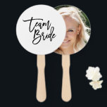 Chique Trendy Zwart Borstel Script Team Bride Handwaaier<br><div class="desc">Laat gasten op uw bruiloft douche, verlovingsfeest of bruiloft koel houden met deze handventilator met "Team Bride" in trendy chic penseelschrift in het zwart tegen een witte achtergrond. Op de achterkant kun je de foto van de bruid toevoegen. Om tekst toe te voegen klikt u op de knop "Aanpassen". *...</div>