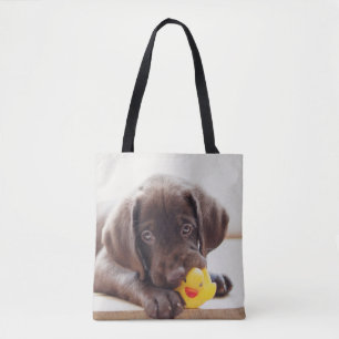 Chocolade Labrador Puppy met Speelgoed Duck Tote Bag