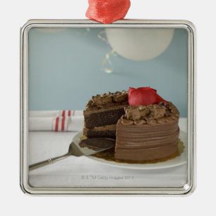 Chocoladecake met ontbrekende plak op tafel, metalen ornament