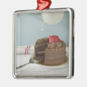 Chocoladecake met ontbrekende plak op tafel, metalen ornament (Links)