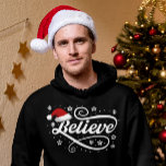 Christmas Believe Santa Claus - Santa Hat Zwart Hoodie<br><div class="desc">Omarm de magie van het vakantieseizoen met ons 'Christmas Believe Santa Claus - Santa Hat Black'-ontwerp. Met een klassieke kerstmuts en de tijdloze boodschap van geloven in de vreugde en het wonder van Kerstmis, is dit feestelijke ontwerp perfect voor het verspreiden van feestvreugde. Of je nu een echte gelovige in...</div>
