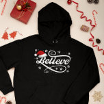 Christmas Believe Santa Claus - Santa Hat Zwart Hoodie<br><div class="desc">Omarm de magie van het vakantieseizoen met ons 'Christmas Believe Santa Claus - Santa Hat Black'-ontwerp. Met een klassieke kerstmuts en de tijdloze boodschap van geloven in de vreugde en het wonder van Kerstmis, is dit feestelijke ontwerp perfect voor het verspreiden van feestvreugde. Of je nu een echte gelovige in...</div>