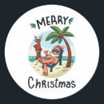 Christmas in July Ronde Sticker<br><div class="desc">Het grappige kerstontwerp met een illustratie van de kerstman die op het strand ontspannen is onder een palmboom op een klein eiland. Een perfecte wedstrijd voor Kerstmis in juli en voor echte Kerstmis in december.</div>