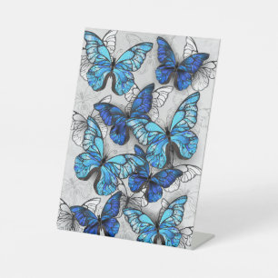 Compositie van witte en blauwe vlinders reclamebord met voetstuk