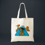 Cookie Monster Eating All the Cookies Tote Bag<br><div class="desc">Satisfy your cravings for fun and cookies with this graphic featuring the one and only Cookie Monster! This showcases a vibrant illustration of Cookie Monster in his element, happily devouring a pile of chocolate chip cookies with crumbs flying everywhere. This classic and instantly recognizable design is cheerful, playful, and sure...</div>