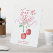 Coquette Cherry | Ze knoopt de knoop door Reclamebord Met Voetstuk (Insitu)