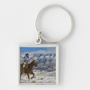 Cowboy op paard die leren chaps draagt sleutelhanger