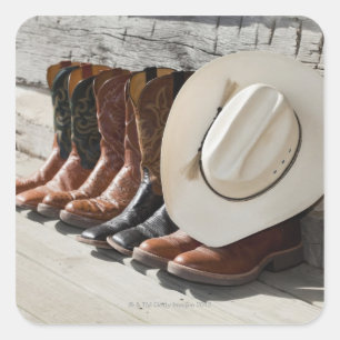 Cowboy pet op rij cowboylaarzen buiten een logboek vierkante sticker