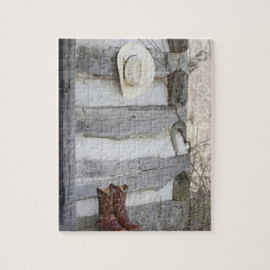 Cowboylaarzen en pet buiten de logcabine legpuzzel (Verticaal)