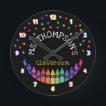 Crayons Sterren Kleurrijke Leraar Naam Klaslokaal Ronde Klok<br><div class="desc">Kleuterschool wandklok gepersonaliseerd met de naam van de leraar onder kleurrijke sterren en boven een rij kleurpotloden in een regenboog gradiënt met de cijfers in vet witte cijfers geschetst met de kleuren van de regenboog. Klaslokaal wandklok met kleurrijke krijtjes en sterren tegen een zwarte achtergrond. De wandklok van de leraar...</div>