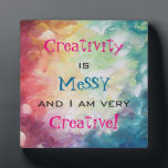 Creativiteit is rommelig en ik ben erg creatief fotoplaat<br><div class="desc">De tekst zegt dat creativiteit rommelig is en ik ben erg creatief. Een abstract schilderij met dikke, expressieve penseelstreken met veel beweging en beweging. Veel zware verf in blauw, geel, rode, oranje en groen. Een artistieke en creatieve stijl. Een inspirerend en grappig citaat/herinnering voor artistieke en creatieve types.</div>