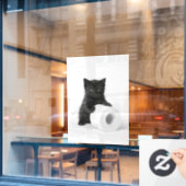 Curious Black Kitten Guarding Toilet Paper Roll On Raamsticker (Cafe Raam)