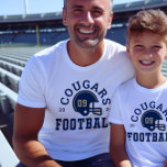 Custom Football Dad Navy Blauw en Goud Team<br><div class="desc">Aangepast T-Shirt voor en achter Football voor papa - getoond in White Design voor football vaders is voorzien van een footballs helm met sportieve tekst die kan worden aangepast voor de teamnaam,  de achternaam van de zoon en zijn truitnummer. Gouden en marineblauwe kleuren kunnen worden aangepast.</div>