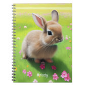 Cute baby rabbit in een bloemwei notitieboek (Voorkant)