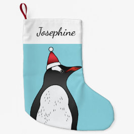 Cute Gentoo Penguin die een kersthat op blauw heef Kleine Kerstsok