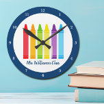Cute Kindergarten Aangepaste Crayon Classroom Ronde Klok<br><div class="desc">Een mooie schoolbekentenis voor een kleuterschool om hun leraar aan de lagere school te geven. Aangepast gemaakte klok met hun naam aangepast in blauw. Personaliseer je met jouw naam of tekst onder de schattige regenboog van krijtjes. Een schattig cadeau voor een voorschoolse leraar.</div>