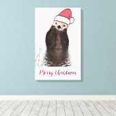 Cute Otter die met Kerstmis een kerstman heeft. Canvas Afdruk (Insitu (Houten vloer))