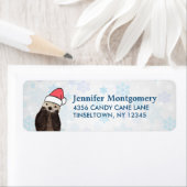 Cute Otter die met Kerstmis een kerstman heeft. Etiket (Insitu)