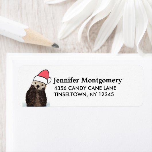 Cute Otter die met Kerstmis een kerstman heeft. Etiket (Insitu)