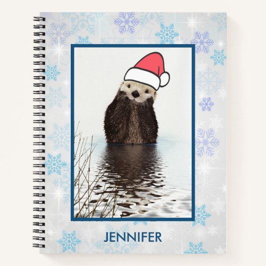 Cute Otter die met Kerstmis een kerstman heeft. Notitieboek (Voorkant)