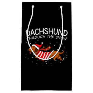 Dachshund door de sneeuwnende hond kerstmis klein cadeauzakje