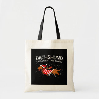 Dachshund door de sneeuwnende hond kerstmis tote bag