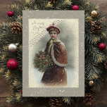 dame in sneeuw met kerstcadeautje feestdagenkaart<br><div class="desc">Een mooie Victoriaans dame verkleed voor de winter in een rode kaap met een heilige bouquet in sneeuw met kerstcadeautjes.</div>