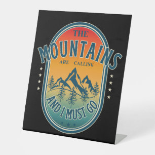 De bergen bellen en ik moet gaan. reclamebord met voetstuk