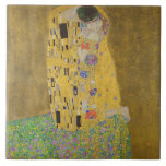 De Geliefden Kussende Omhelzing door Gustav Klimt Tegeltje<br><div class="desc">Zonlicht schittert van de wervelende gouden omhelzing die de geliefden omringt in het meesterwerk De Kus van Gustav Klimt. De scène is een paradox van intimiteit en isolement. Het paar staat op een afgrond, een veld van kleurrijke bloemen aan hun voeten, maar ze zijn zich niet bewust van de wereld...</div>