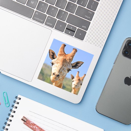 De Giraffe staat dicht bij een blauwe hemel Sticker (Laptop met iPhone)