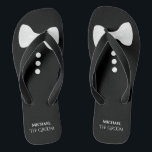 De Groom. Stropdas en Buttonnen rond de witte vlin Teenslippers<br><div class="desc">Deze schattige teenslippers zijn ideaal voor de bruidegom wanneer hij klaar is om zijn schoenen uit te trekken en te feesten. Ze zijn voorzien van een leuke mock smoking ontwerp met een witte boog stropdas en knoppen aan de bovenkant en zijn naam en titel hieronder.</div>