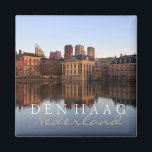 De Haagse skyline in Nederland tekstmagneet Magneet<br><div class="desc">Souvenir fotomagneet met de moderne skyline van het centrum van Den Haag samen met het historische Mauritshuis museum en de zetel van het Rijksparlementsgebouw met reflectie in het stilstaande water van het Hofvijver meer bij schemering in Nederland met de tekst: 'Den Haag, Nederland', Nederlands voor 'Den Haag, Nederland'.</div>