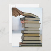 De hand die van het man een boek van een stapel briefkaart (Voorkant / Achterkant)