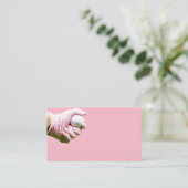 De hand in de roze handschoen houdt golfbal vast visitekaartje (Staand voorkant)