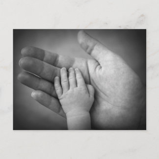 De hand van de baby van briefkaarten in de hand va