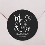 de heer Mrs Black Wedding Ronde Sticker<br><div class="desc">Een zwarte zelfklever voor je trouwcorrespondentie en feestvieren met "Mr & Mrs." in een groot wit script en een witte illustratie van twee harten. Voeg jouw naam en trouwdatum toe.</div>