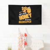De imker koopt plaatselijke honing en ondersteunt  spandoek (Insitu)