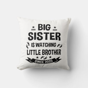 De kleine zus zorgt voor de grote broer in kussen