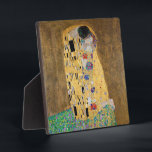 De kus van Gustav Klimt Fotoplaat<br><div class="desc">De Kiss van Gustav Klimt De Kiss is een olieverf op doek met toegevoegd bladgoud, zilver en platina. door de Oostenrijkse symbolistische schilder Gustav Klimt. Het werd geschilderd in 1907 en 1908, tijdens het hoogtepunt van wat geleerden zijn "Gouden Periode" noemen. Met glinsterende gouden tinten, gestileerde vormen en sentimentele iconografie...</div>