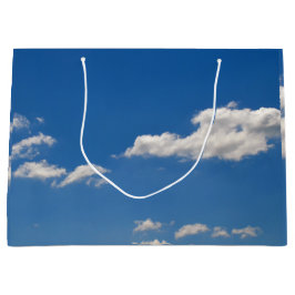 De lucht is blauw en witte wolken trekken voorbij  groot cadeauzakje