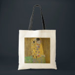 De minnaars omhelzen elkaar by Gustav Klimt Tote Bag<br><div class="desc">Zonlicht schittert van de wervelende gouden omhelzing die de geliefden omringt in het meesterwerk De Kus van Gustav Klimt. De scène is een paradox van intimiteit en isolement. Het paar staat op een afgrond, een veld van kleurrijke bloemen aan hun voeten, maar ze zijn zich niet bewust van de wereld...</div>