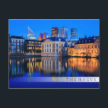 De skyline van Den Haag op briefkaart met een blau<br><div class="desc">Briefkaart van de skyline van de stad Den Haag, het regeringscentrum van Nederland, aan het begin van de avond bij Blue Hour met de moderne architectonische skyscrapers achter het historische Mauritshuis-museum, Binnenhof van het parlement en het Hofvijver-meer met een witte vegende staaf en de tekst: 'Den Haag'.</div>