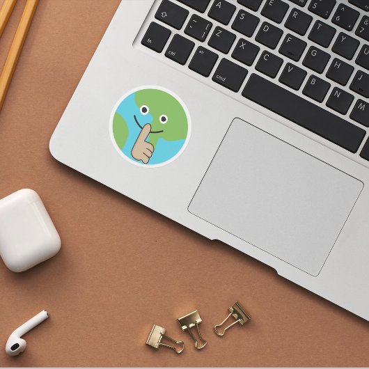 De wereld die hand in hand houdt in de buurt van m ronde sticker