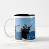 De zeelieden schieten een pistool saluut in tijden tweekleurige koffiemok (Links)