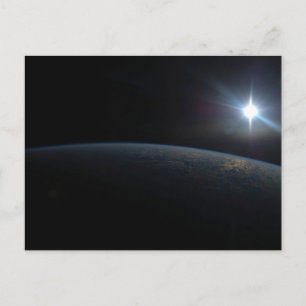 De zon gaat onder aan de horizon van de aarde. briefkaart